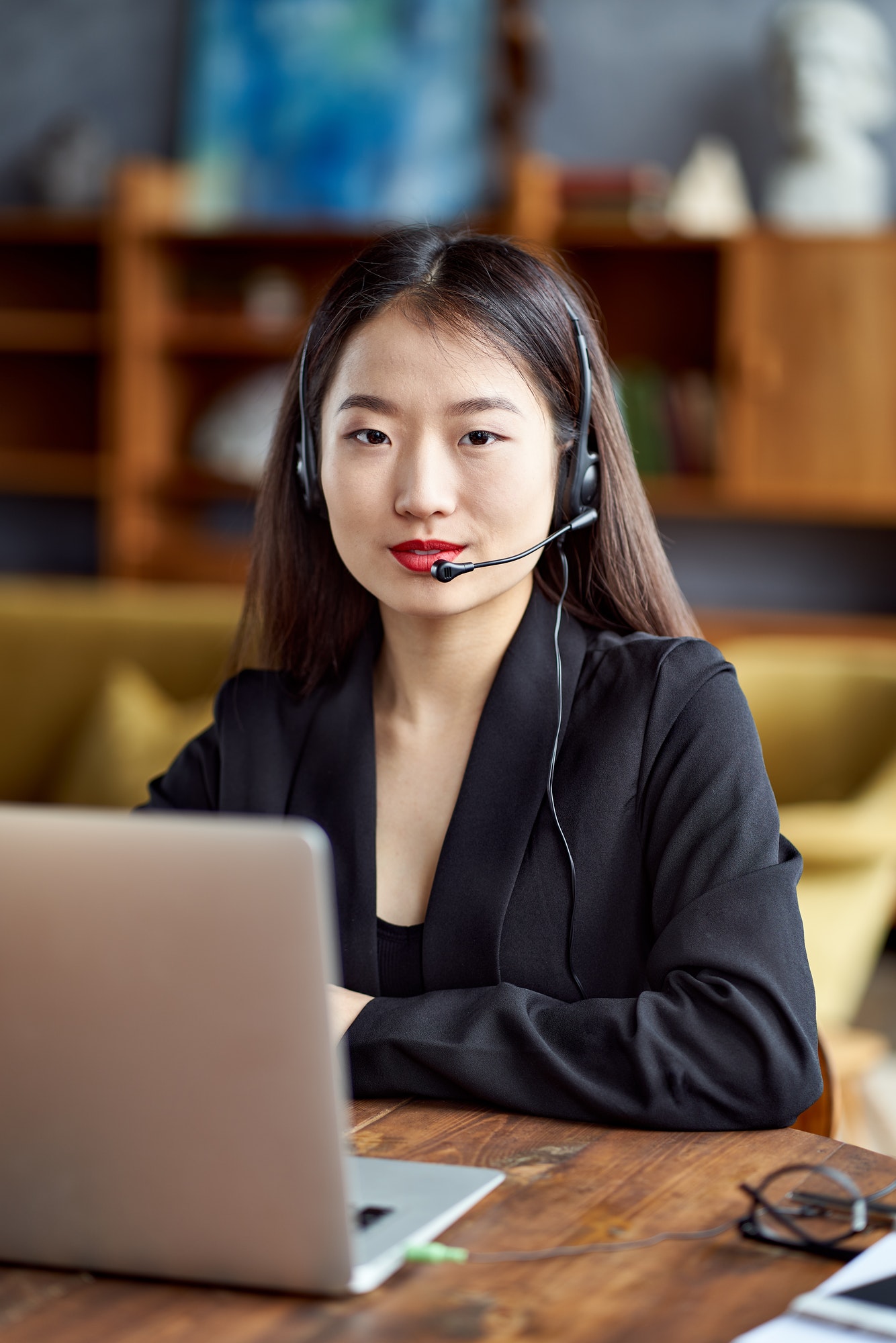 Happy asian businesswoman in headset speaking by conference call and video chat