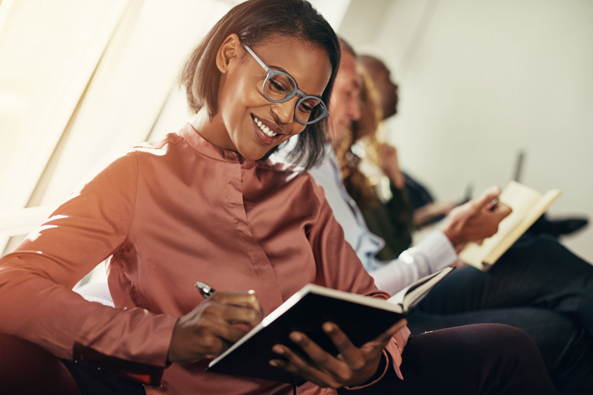 smiling-african-businesswoman-taking-notes-during-Q7REVA5.jpg